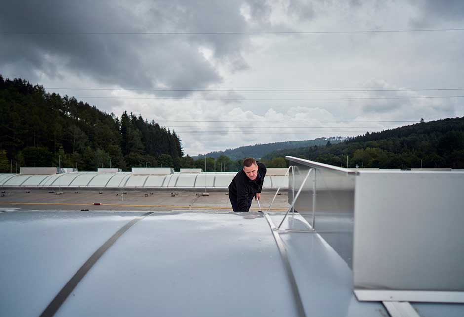 Homme sur un toit qui regarde un lanterneau