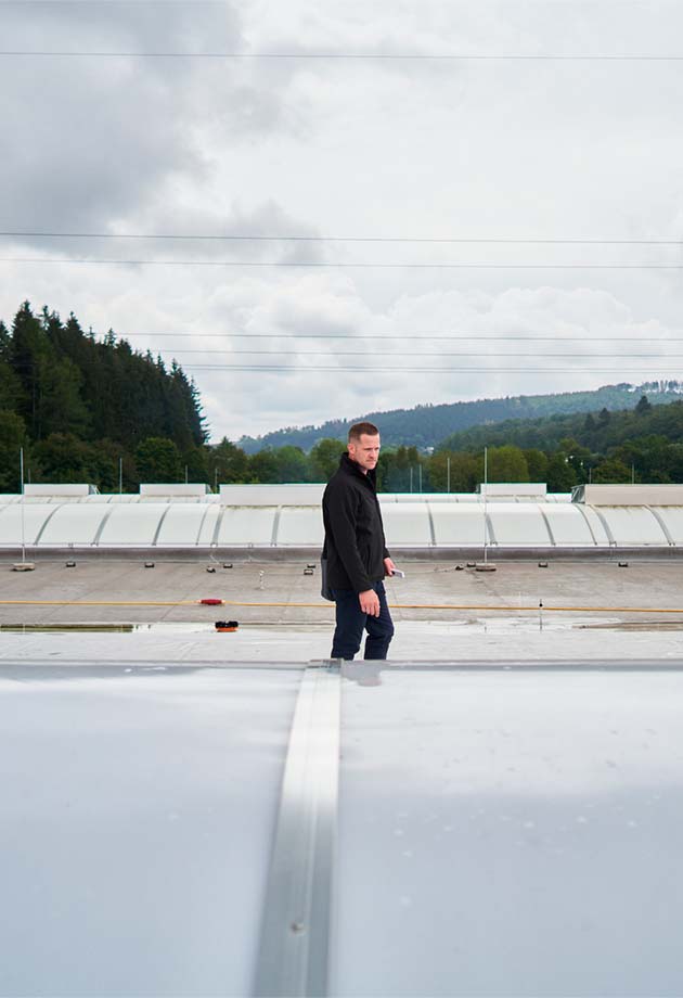 Ein Mann betrachtet die Lichtbandlösung auf dem Dach
