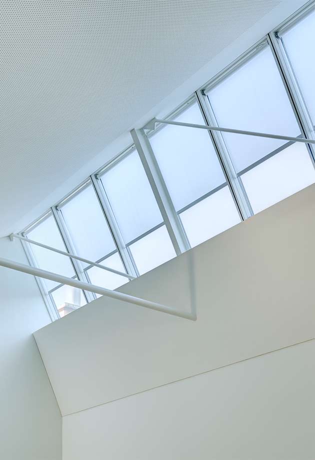  Świetlik biurowy składający się z pasma świetlnego szedowego 25°–90° ze zintegrowanymi roletami; biuro architektoniczne Weber Hofer AG, Zurych 