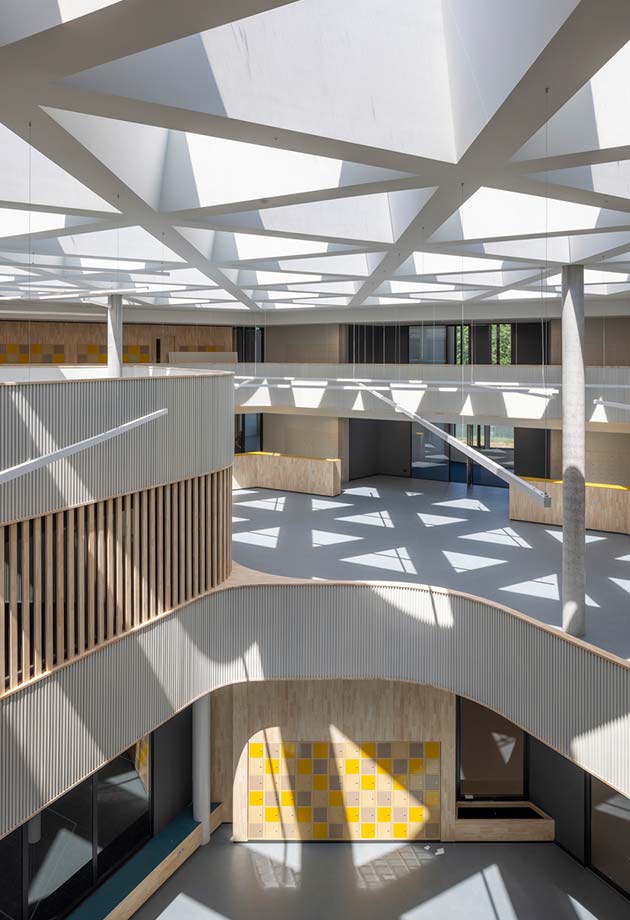 Prise de vue intérieure du Collège Knippenberg avec le produit Velux Commercial mettant en valeur la lumière du jour.