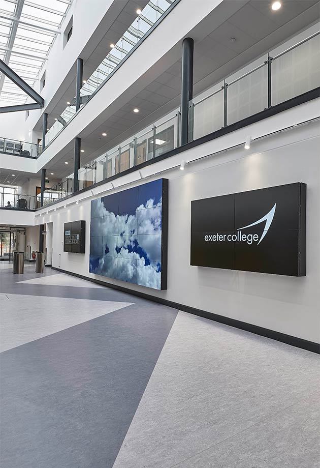 Interior image of the Exeter College building, ground floor with TV display and building logo.