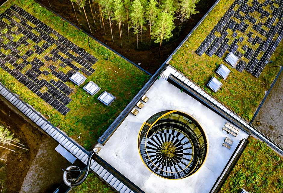 Nærbilde av det grønne taket der overlys moduler og solcellepaneler er synlige.