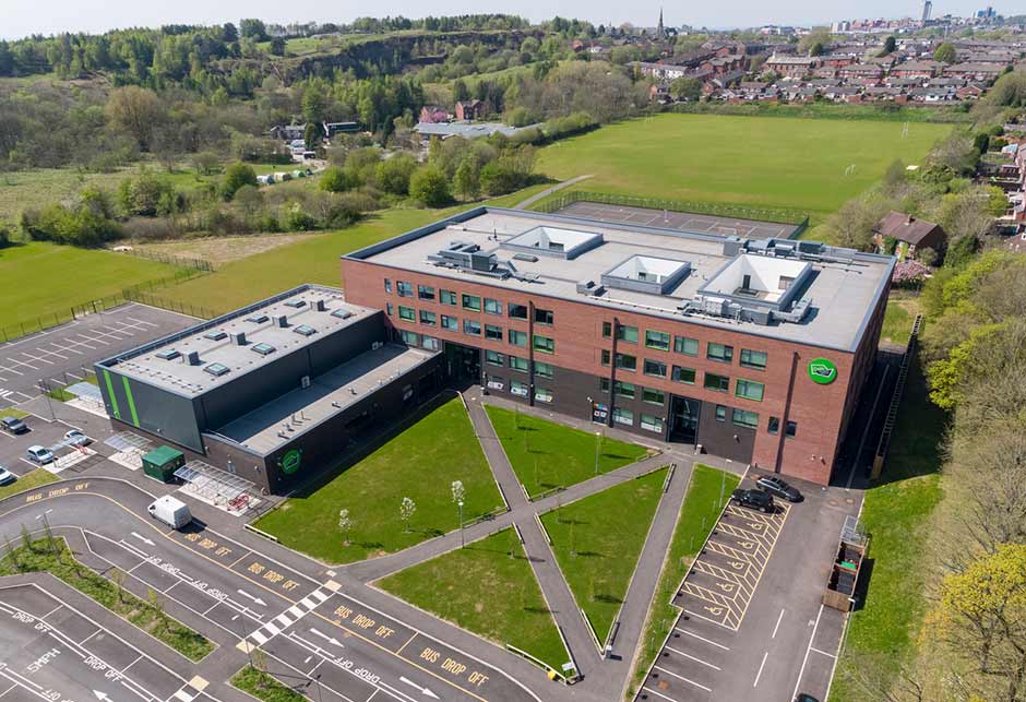 Luchtfoto van het schoolgebouw van de Oasis Academy met VMS lessenaarsdak