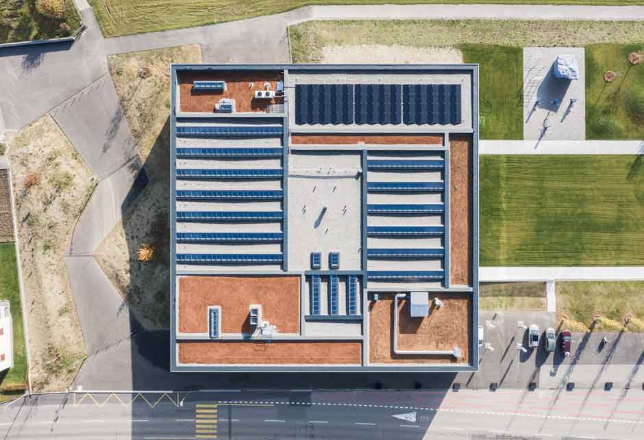 Alternate Text: Daylight solution with VELUX Modular Skylights as a 5-30° continuous rooflight / Piscine de Romont, Switzerland / Exterior view from above 2  