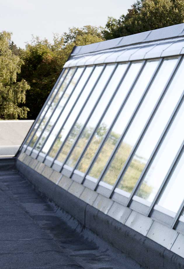 Przeszklenie dachu składające się z modułów pasmo świetlne szedowe 40–90˚, Sågbäcksgymnasiet, Huddinge, Szwecja