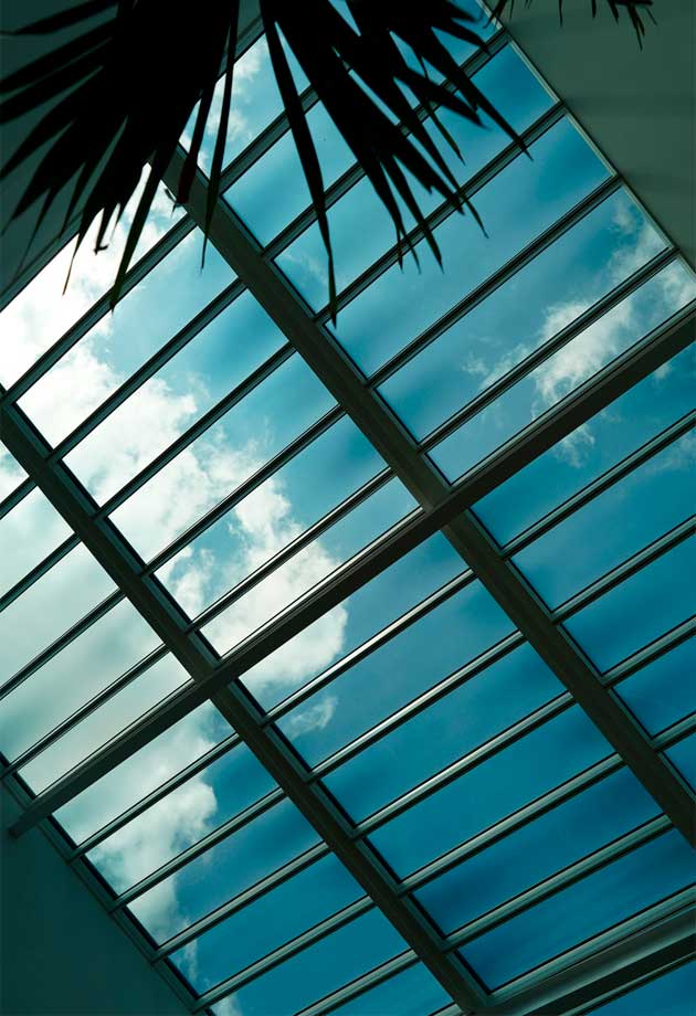 A view of clouds forming seen through skylight window installations